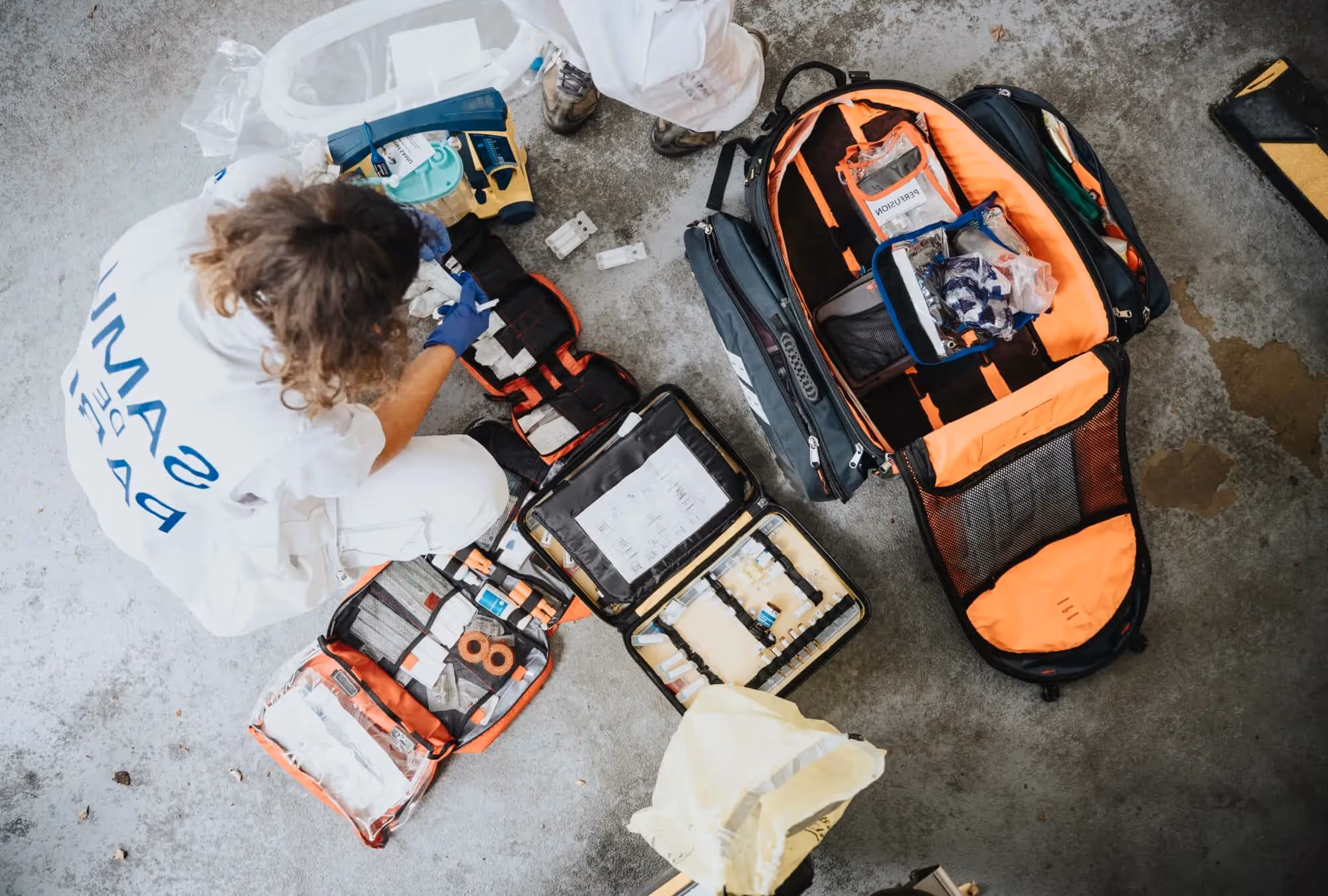 Person with first aid kit helping an injured construction worker